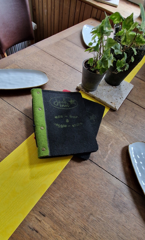 Gemütliche Sitzecke in der Jack Inn Gaststube mit Holztischen und Pflanzen